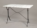 une table avec un plateau en marbre blanc, des pieds en fer et un piètement noir