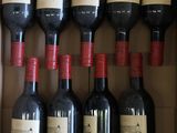 Plusieurs bouteilles de vin sont posées dans une boîte en carton sur une table