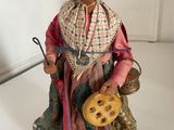 figurine of an old woman holding a pot and a cane
