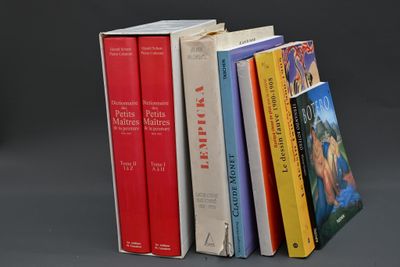 plusieurs livres sont empilés sur une surface grise