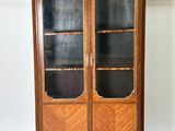 an image of a wooden cabinet with glass doors in a room