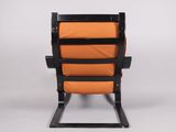 a black and orange chair sitting on top of a white floor