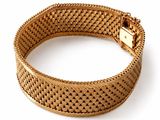 a close up of a gold bracelet on a white background
