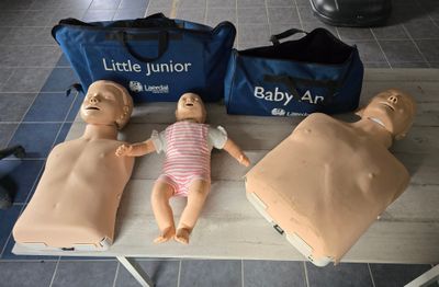 three mannequins on a table with a bag and a bag behind them
