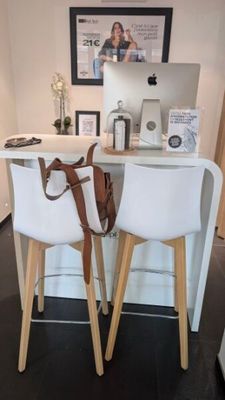 deux chaises blanches devant un bureau sur lequel se trouve un ordinateur