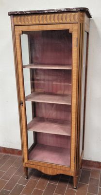 une grande armoire en bois avec des étagères, placée dans un coin de la pièce