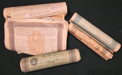 quelques vieux papiers et un rouleau de papier enroulé posés sur une table
