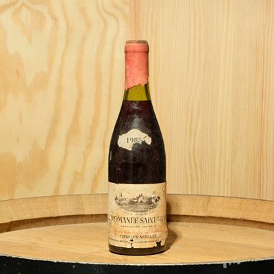 a bottle of wine sitting on top of a wooden barrel