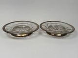 two glass dishes with gold rims on a white surface