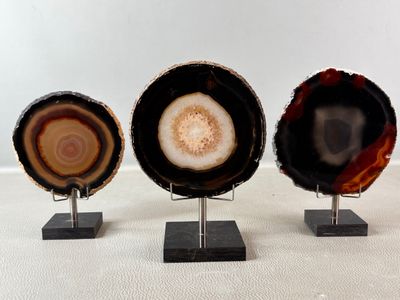 trois morceaux d'agate posés sur des socles, sur fond blanc