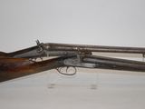 two old guns are on display in a museum display case