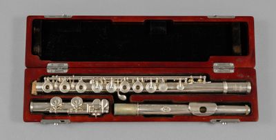 a silver flute in a red case on a table