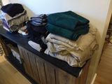a picture of a pile of clothes sitting on top of a wooden bench