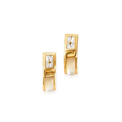 une paire de boucles d'oreilles en or jaune serties de diamants sur fond blanc