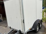 a trailer that is parked in front of a barn