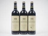 three bottles of red wine sitting on top of a white table
