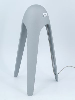 une lampe grise posée sur une table blanche