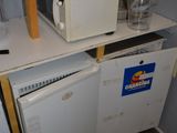 deux micro-ondes et un lave-vaisselle posés sur une étagère dans une cuisine