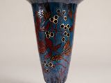 a blue vase with a design on it sitting on a table