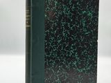 a book with a green cover sitting on top of a white table