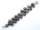 a close up of a bracelet with black pearls on a white background