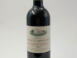 la bouteille de vin rouge est posée sur une surface blanche
