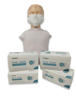 une tête de mannequin sur laquelle sont posées trois boîtes de masques