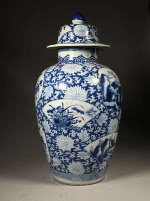 a blue and white vase with a lid sitting on a table