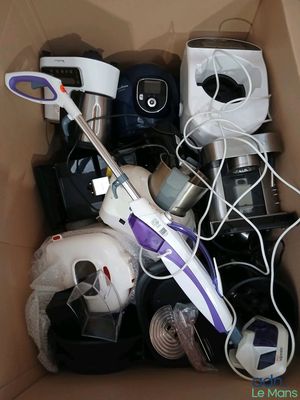 un carton rempli d'articles ménagers, notamment un aspirateur et d'autres objets