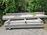 Plusieurs morceaux de bois sont empilés les uns sur les autres devant un buisson