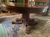 a large wooden table on a rug in a living room
