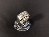 a close up of a silver ring on a black surface