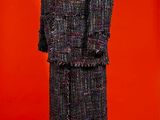 a mannequin dressed in a black and white tweed coat and skirt