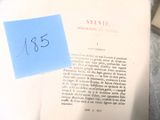 un bout de papier posé sur un livre sur lequel est collé un autocollant bleu