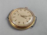 a small gold pocket watch sitting on a table