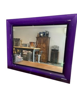 un miroir violet accroché au mur d'une pièce