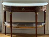 a small table with a marble top on a hard wood floor