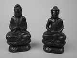 two black buddha statues sitting on top of each other