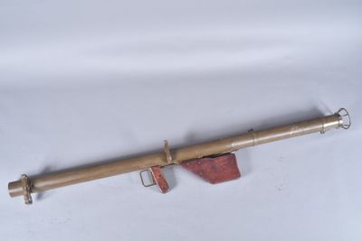 an old brass telescope on a white surface with a wooden handle