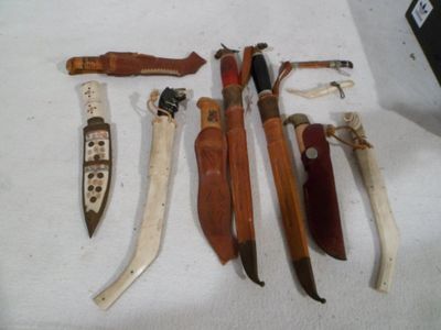 many different types of knives on a white table
