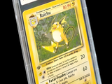 La carte Pokémon se trouve dans un étui en plastique transparent sur fond noir.