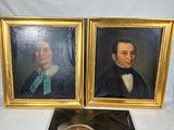 deux portraits encadrés représentant un homme et une femme, posés sur une table