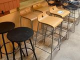 many stools lined up in a row in front of a window