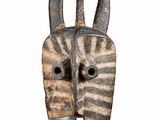 an image of a wooden mask with horns on a white background
