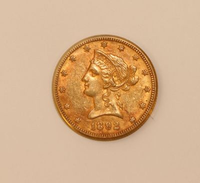 a close up of a gold coin with a woman ' s head on it