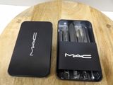 an open box of mac pencils sitting on top of a wooden table