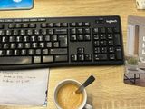 a computer keyboard and mouse on a desk next to a cup of coffee