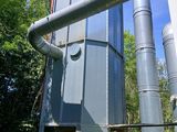 une structure métallique avec des tuyaux et un seau bleu devant elle