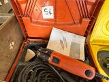 une boîte à outils contenant des outils, posée sur le sol