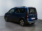 the small blue van is parked in a large room